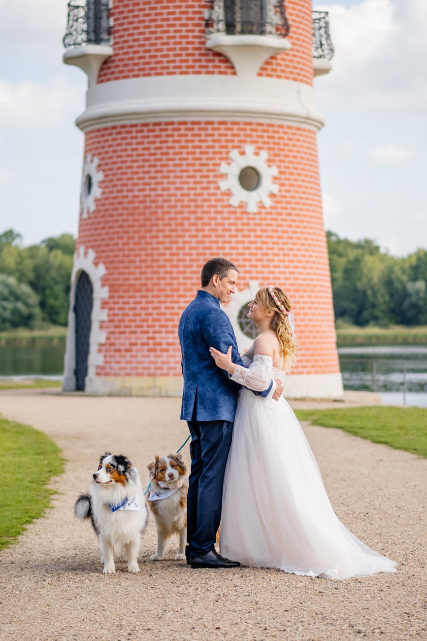 Brautpaar mit zwei Hunden vor dem Leuchtturm in Moritzburg